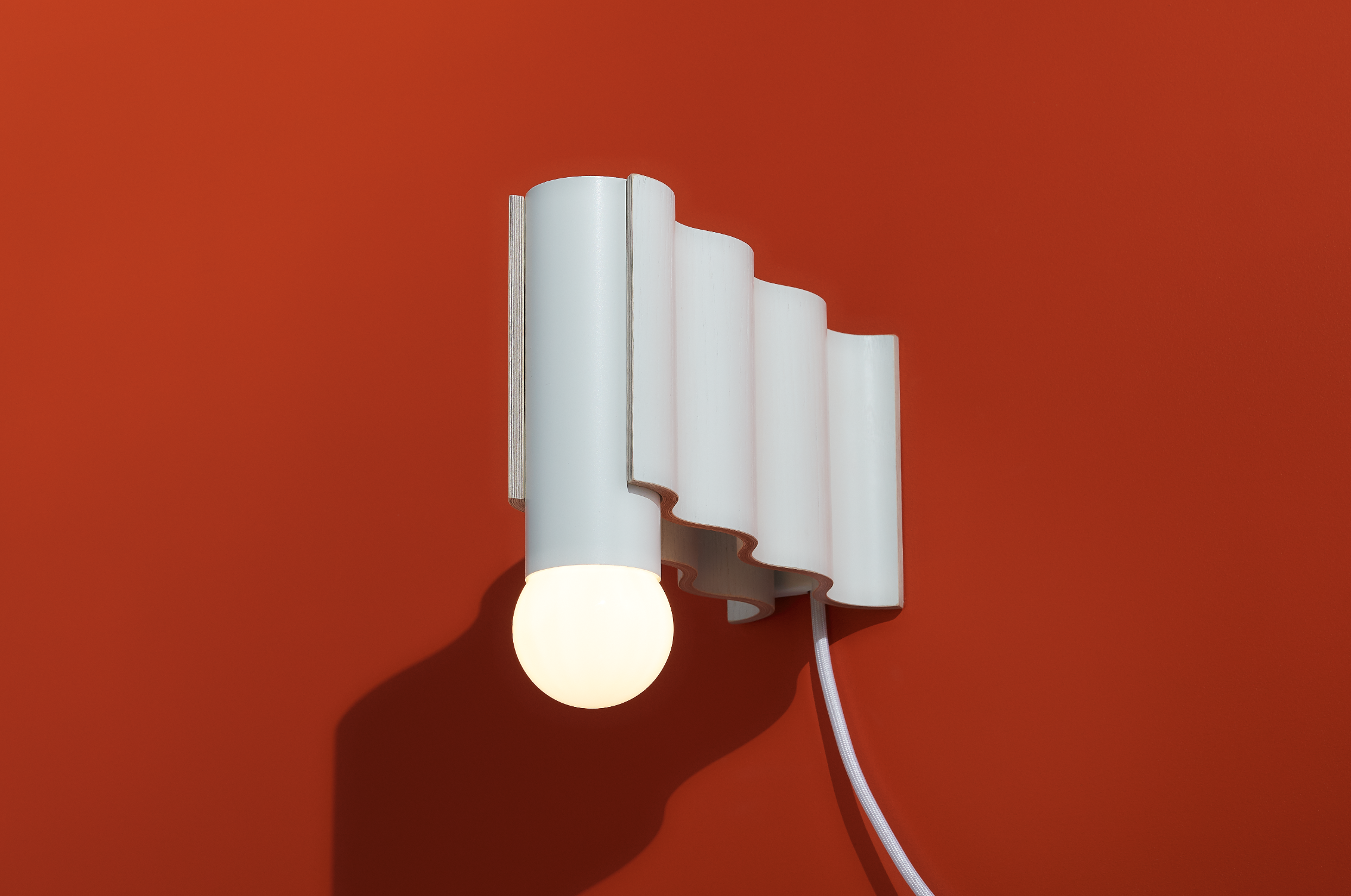 Corrugation is a collection of lights inspired by mid-century furniture making, honouring the technique of veneer forming. It consists of a scalable hanging light and wall sconces, which can serve as building blocks.